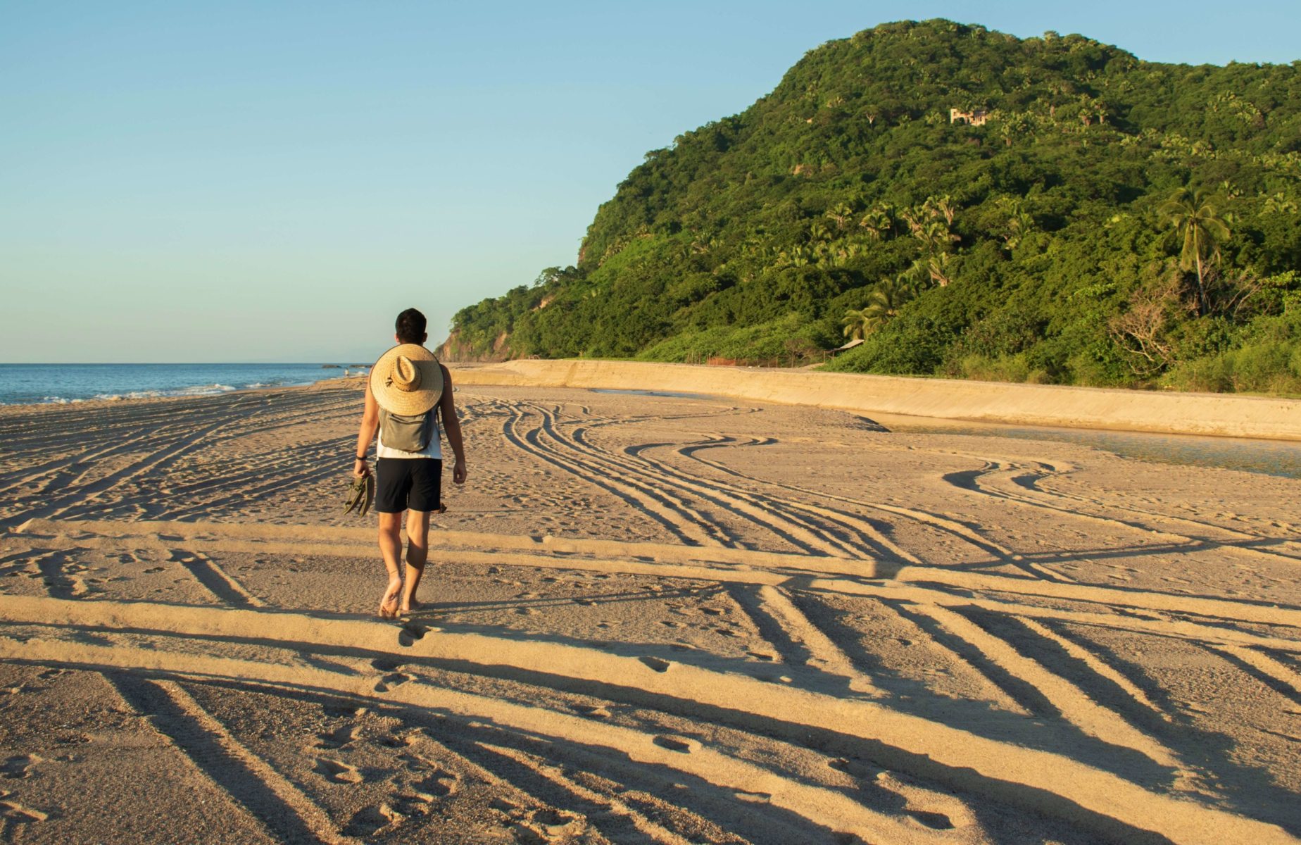 A man hiking in Puerto Vallarta on a beach.