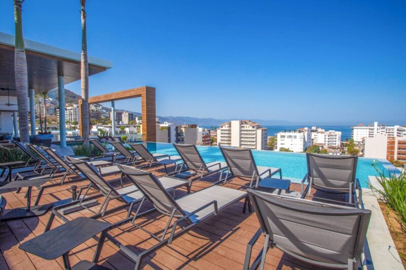 Loungers on the Desire rooftop deck facing the bay