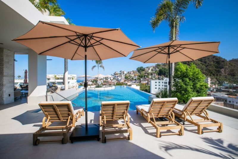 Loungers and umbrellas beside the Dvine rooftop pool