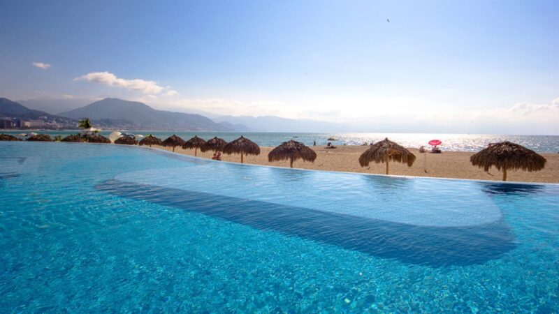 The beachfront infinity pool at Grand Venetian, with the bay and mountains beyond