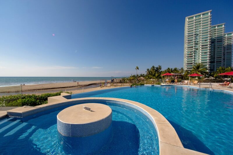 A pool and jacuzzi at Grand Venetian, with the beach behind