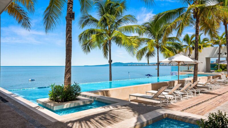 The beachfront infinity pool at Harbor 171, with palms and Banderas Bay