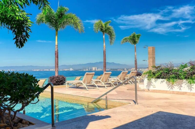 Loungers by a pool at Indah, facing the bay