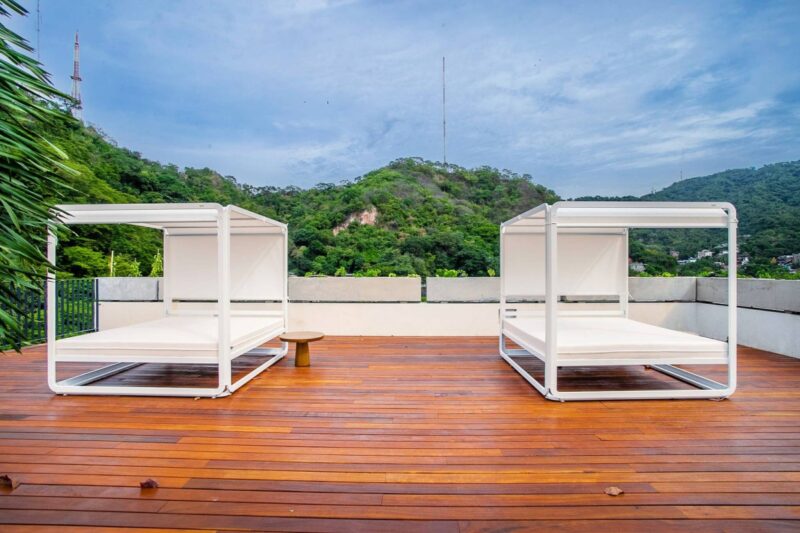 Day beds on the Oasis rooftop, with the green hills behind