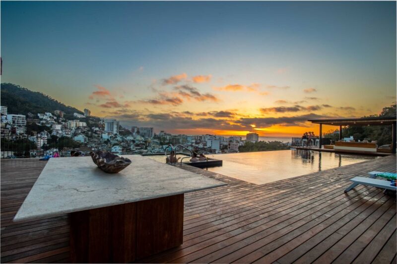The Oasis rooftop infinity pool at sunset, looking over Puerto Vallarta to the bay