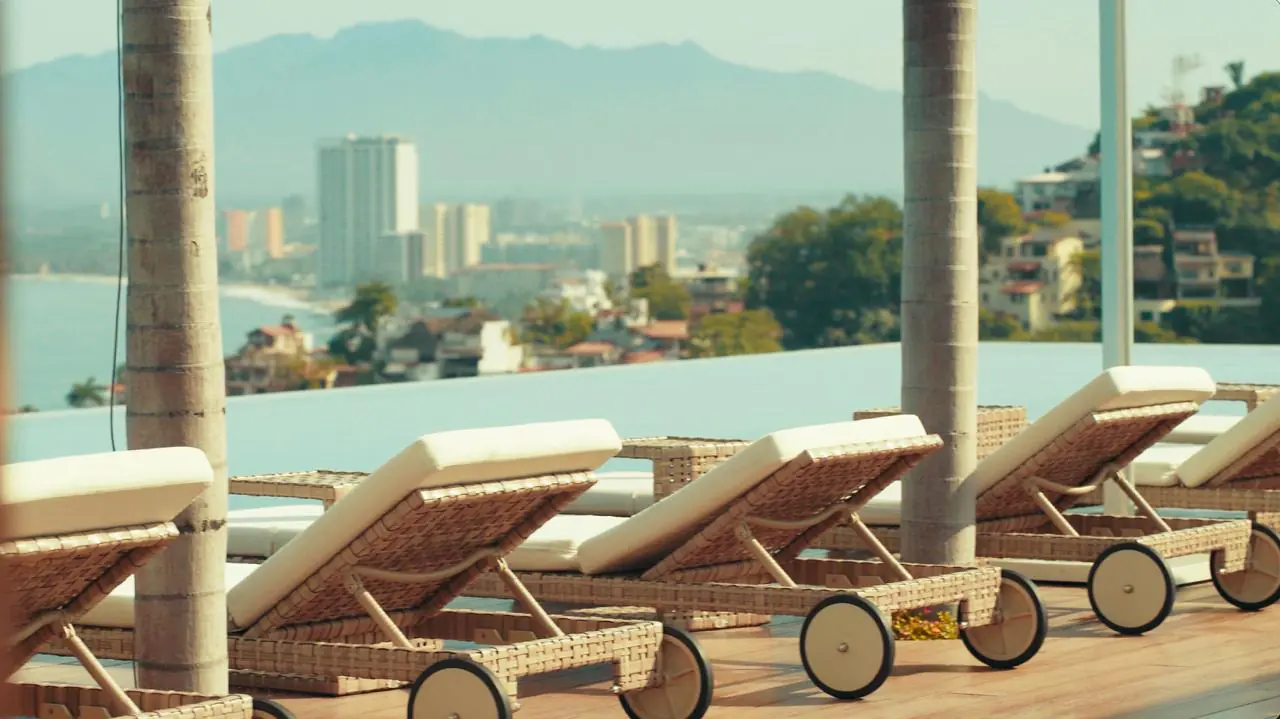 Rooftop infinity pool with loungers overlooking Puerto Vallarta and the bay