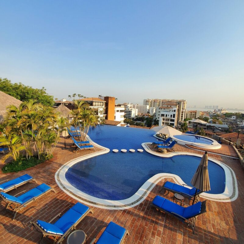 The Selva Romantica pool and loungers, with the city and Banderas Bay beyond