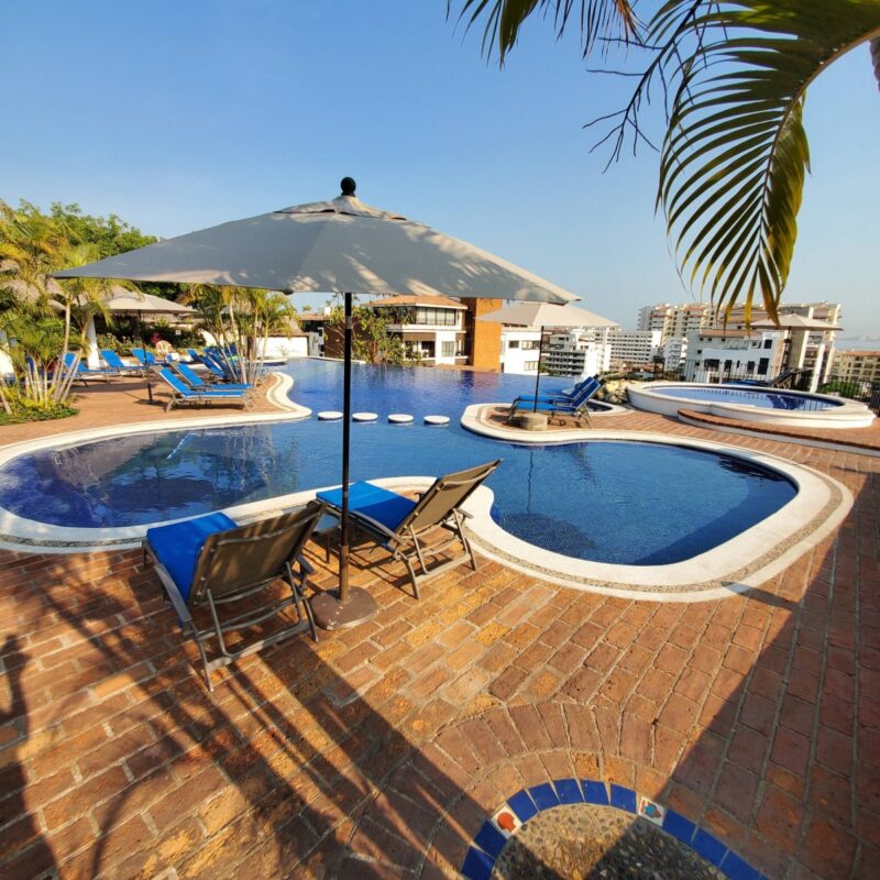 Loungers under an umbrella by the Selva Romantica pool